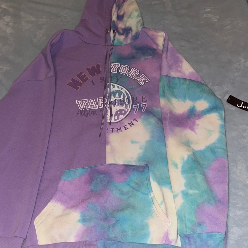 Never worn justify women’s hoodie purple, white, and light blue size Large.